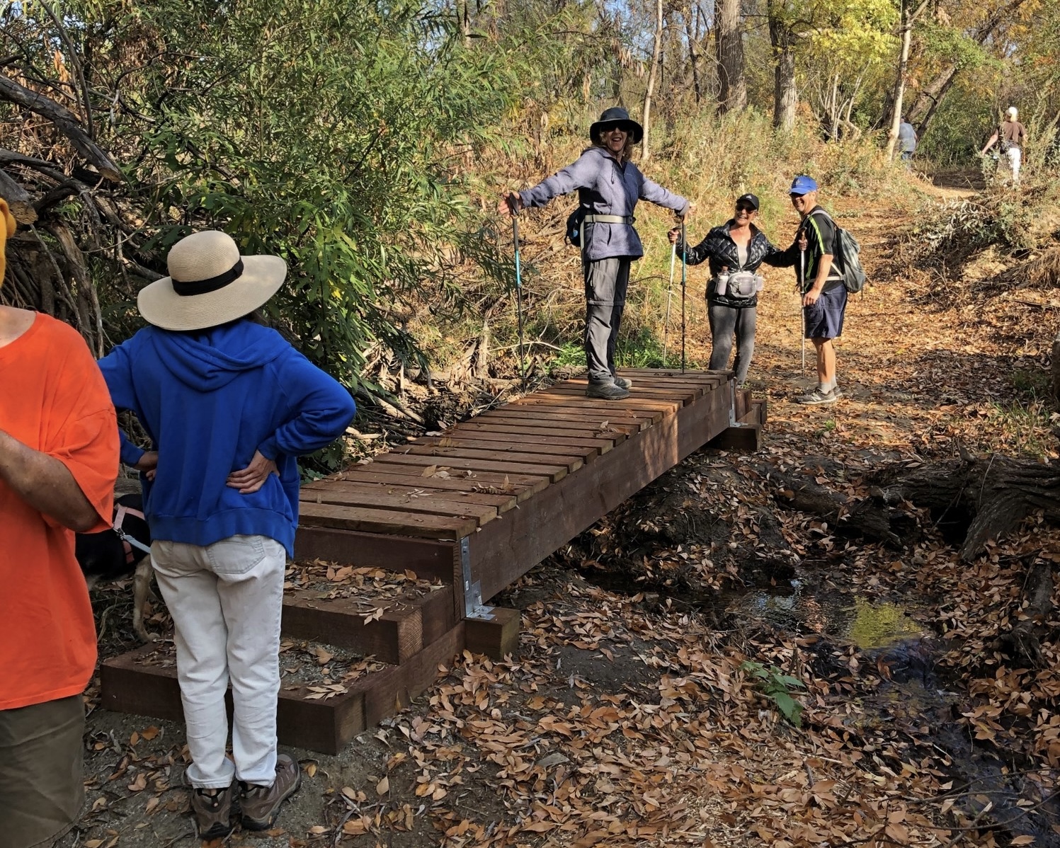 woman standing on foot bridge with hiking group
